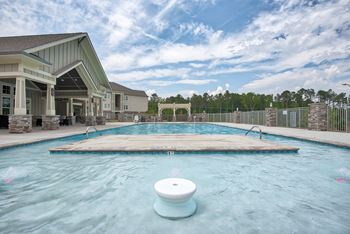 Resort-style pool with tanning shelf and sun deck